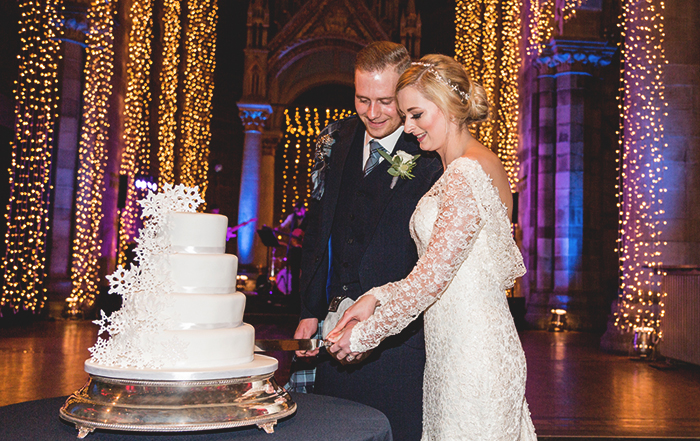 Bride and groom cutting their snowflake themed wedding cake. Venue - Mansfield Traquair in Edinburgh. Photographer: Philip Stanley Dickson www.psdphotography.co.uk