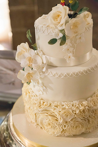 Beautiful white wedding cake with bride and groom lego figures! Photo credit: Kirsty Stroma Photography. Venue: Mansfield Traquair, Edinburgh 