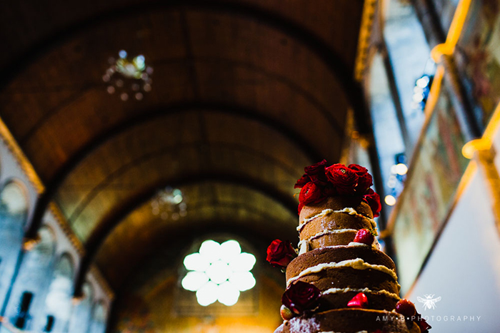 naked wedding cake decorated with red roses