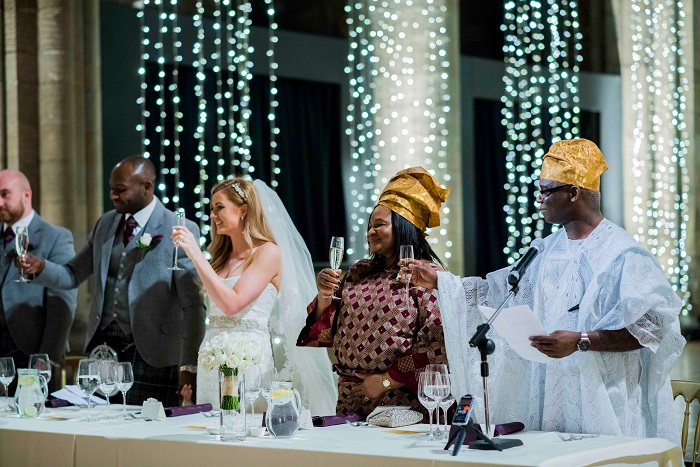 A beautiful bride and groom sat with their family in Mansfield Tranquair toasting their new marriage