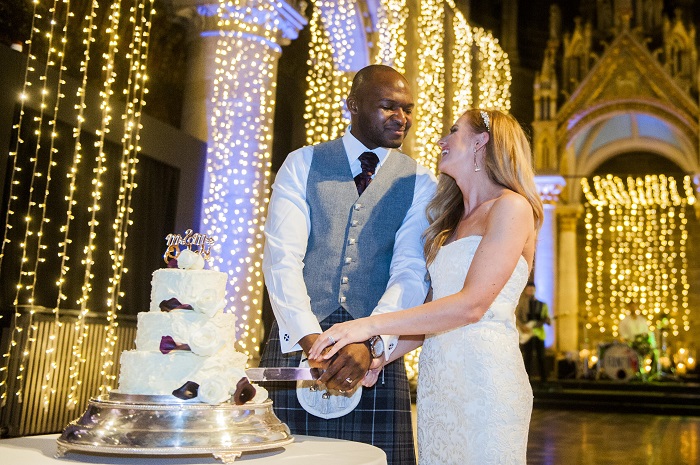A newly married couple cutting their wedding cake in Mansfield Tranquair, Edinburgh 